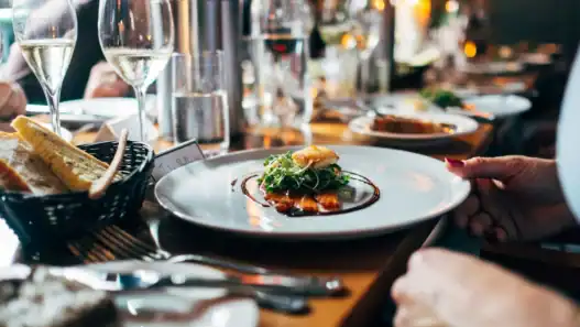 Elegant dish served at a French restaurant in Calgary with wine, bread, and warm ambiance.