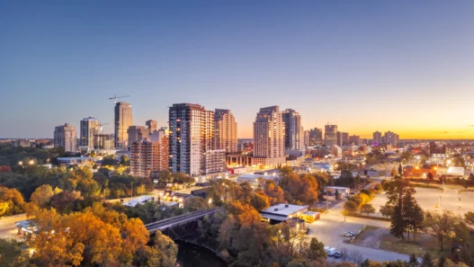 Downtown London, Ontario at sunset with the Thames River and summer trees in view.