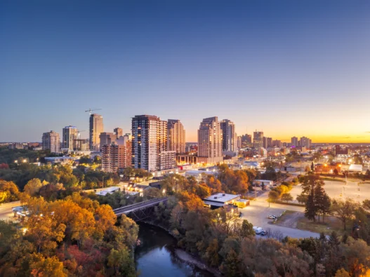 Downtown London, Ontario at sunset with the Thames River and summer trees in view.
