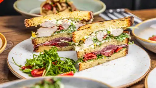 Stacked sandwich perfection at a top brunch restaurant in Edmonton, served with fresh greens