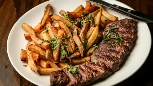 Steak frites at a French restaurant in Montreal with crispy fries and grilled herb-seasoned steak.