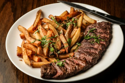 Steak frites at a French restaurant in Montreal with crispy fries and grilled herb-seasoned steak.