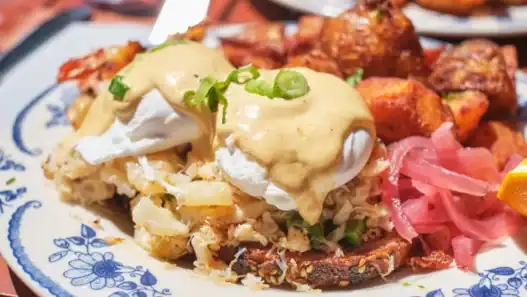 Signature eggs Benedict with crispy potatoes at one of the top brunch restaurants in Toronto.