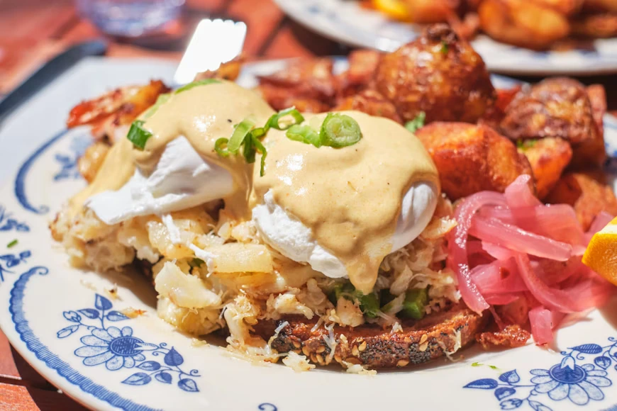 Signature eggs Benedict with crispy potatoes at one of the top brunch restaurants in Toronto.
