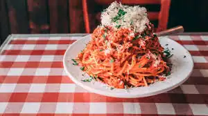 Fresh plate of spaghetti topped with cheese at a cozy Italian restaurant in Toronto.